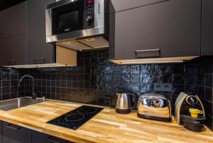 eine Küche mit einer hölzernen Arbeitsplatte und einer Spüle in der Unterkunft CMG Friedland // Champs Elysées in Paris