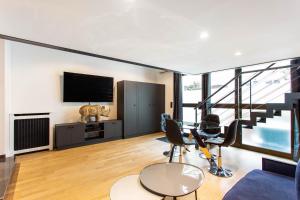 a living room with a flat screen tv and chairs at CMG Friedland // Champs Elysées in Paris