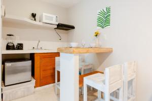 a kitchen with a counter and two white chairs at Rentalife Playa in Playa del Carmen