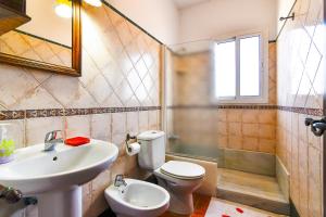 a bathroom with a sink and a toilet and a shower at Villas Dehesa Roche Viejo in Conil de la Frontera