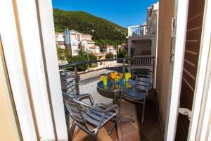 balcón con mesa, sillas y vistas en Adzic Apartments, en Budva