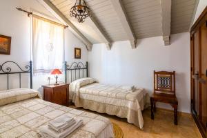 een slaapkamer met 2 bedden, een tafel en een raam bij Villas Dehesa Roche Viejo in Conil de la Frontera