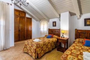 een slaapkamer met 2 bedden, een tafel en een raam bij Villas Dehesa Roche Viejo in Conil de la Frontera