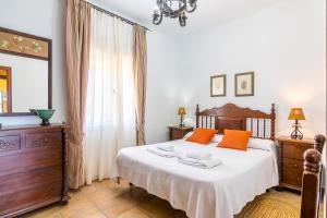 1 dormitorio con 1 cama grande con almohadas de color naranja en Villas Dehesa Roche Viejo, en Conil de la Frontera