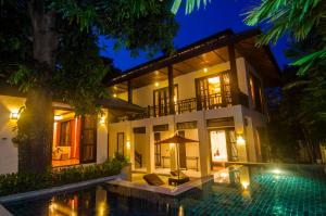 a villa with a swimming pool at night at Kirikayan Residences Koh Samui in Mae Nam
