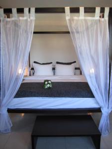ソポトにあるHotel Shterev Anevoの白いカーテンが付いた部屋のベッド1台