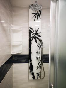 a shower in a bathroom with a black and white wall at Apartment Decumana in Krk