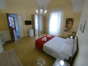 Schlafzimmer mit einem großen Bett mit roter und weißer Bettwäsche in der Unterkunft Palazzo Rondine - Affittacamere con cucina in Presicce