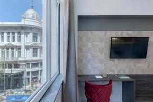 Televízia a/alebo spoločenská miestnosť v ubytovaní Philosofia Athens Suites