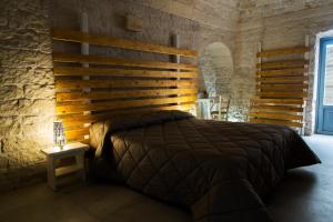 une chambre avec un lit avec une tête de lit en bois dans l'établissement Dimore Miravalle, à Martina Franca