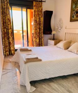 een slaapkamer met een groot wit bed en een raam bij Apartamento Milla De Oro Marbella in Marbella