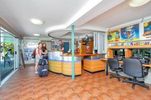 two people standing at a bar in a restaurant at Caravella Backpackers in Cairns +37 photos