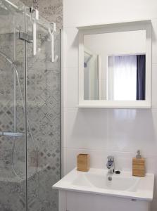 a white bathroom with a sink and a shower at Apartments Nino 1 in Zadar +15 photos