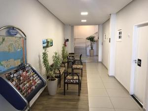 Suites Residence في ريسيفي: ممر مع طاولة وكراسي في مبنى