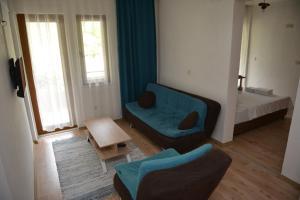 a living room with a blue couch and a bed at Double Comfort Otel in Muğla