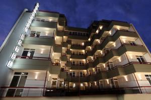 a tall building with lights on it at night at Hotel Metropol in Larisa