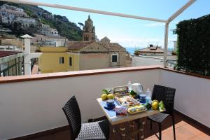 una mesa en un balcón con vistas a la ciudad en Beautiful Lights Guest House, en Amalfi