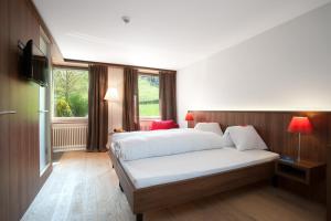 a bedroom with a bed and a window at Seehotel Delphin in Meisterschwanden