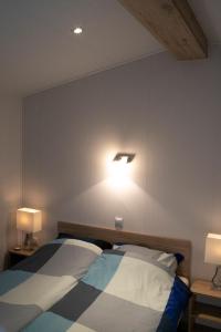 1 Schlafzimmer mit 2 Betten und 2 Lampen an der Wand in der Unterkunft Zuiderzee-chalet 22 in Molkwerum