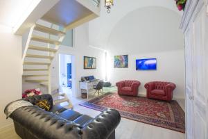 a living room with a staircase and a leather couch at La Finestra sul Convitto B&B in Lecce