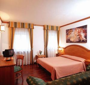 a hotel room with a bed and a couch at Albergo Scarpone in Forni Avoltri