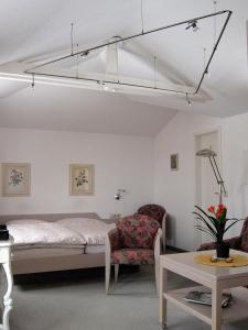 a bedroom with a bed and a chair and a table at Uns Gartenhus mit Blick auf das Meer in Thiessow