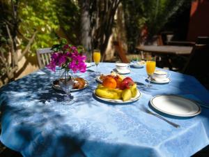 einen blauen Tisch mit Obstteller und Gläsern Orangensaft in der Unterkunft Hotel Il Vecchio Mulino in Àrbatax