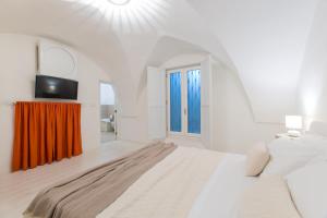 une chambre blanche avec un lit et une télévision dans l'établissement La Finestra sul Convitto B&B, à Lecce