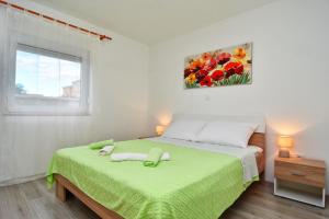 a bedroom with a bed with green sheets and a window at Kuća za odmor Diana in Sukošan +51 photos