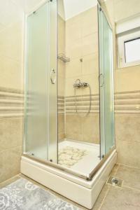 a shower with a glass enclosure in a bathroom at Kuća za odmor Diana in Sukošan