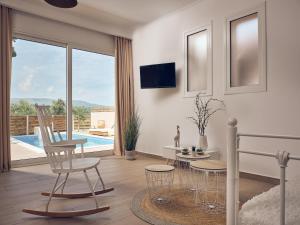 een woonkamer met een tafel en stoelen en een zwembad bij Lofos Soilis in Tragaki