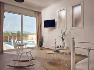 a living room with a table and chairs and a pool at Lofos Soilis in Tragaki