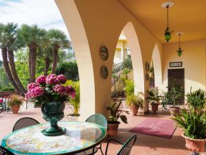 a patio with a table with a vase of flowers at Hotel Sirius in Taormina