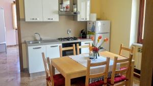 eine Küche mit einem Tisch und Stühlen sowie eine Küche mit einem Kühlschrank in der Unterkunft Sopra La Spiaggia in Bogliasco