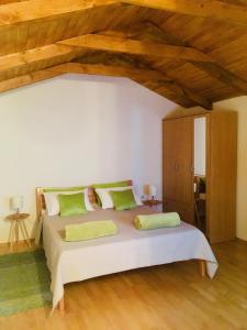 1 dormitorio con 1 cama blanca grande con almohadas verdes en Soba Agata en Slunj