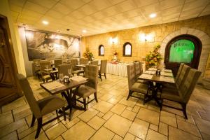 a restaurant with tables and chairs and a television at Hotel La Mansion Suiza in Aguascalientes