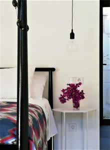 Un dormitorio con una cama y una mesa con un jarrón de flores en Idayvuelta Home & Suites, en Ses Salines