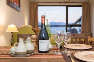 - une table avec une bouteille de vin et des verres dans l'établissement Studio Bariloche, à San Carlos de Bariloche