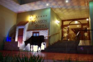Hotel La Mansion Suiza في اغواسكالينتيس: مبنى امامه تمثال بقر