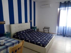 a bedroom with a bed and blue and white stripes at La Melagrana in Castellammare del Golfo