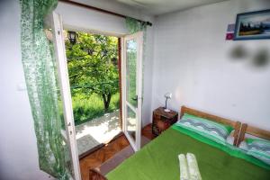 a bedroom with a green bed and a sliding glass door at Green garden apartments in Rovinj