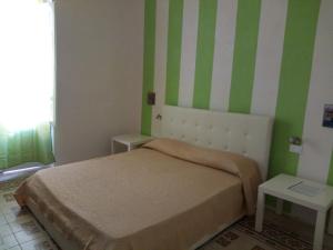 a bedroom with a bed with green and white stripes at La Melagrana in Castellammare del Golfo