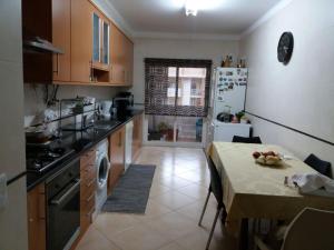 a small kitchen with a table and a kitchen with a refrigerator at 3 Bedroom Apartment with pool Alvor in Alvor