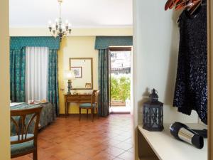 a living room with a table and a desk and a room at Hotel Sirius in Taormina