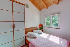 a bedroom with a bed and a window at Apartments Savar - Ilo in Brbinj