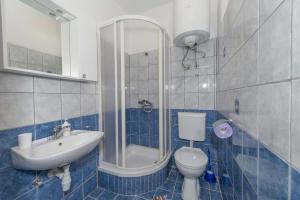 a blue and white bathroom with a toilet and a sink at Apartments Savar - Ilo in Brbinj +32 photos