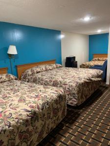 duas camas num quarto de hotel com paredes azuis em Blue Falls Motel em Tonawanda