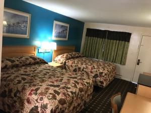 um quarto de hotel com duas camas e uma mesa em Blue Falls Motel em Tonawanda