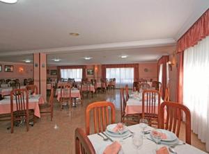 un comedor con mesas y sillas en un restaurante en Hotel Pipo, en A Lanzada