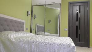 a bedroom with a white bed and a mirror at E-Home Batumi in Batumi
